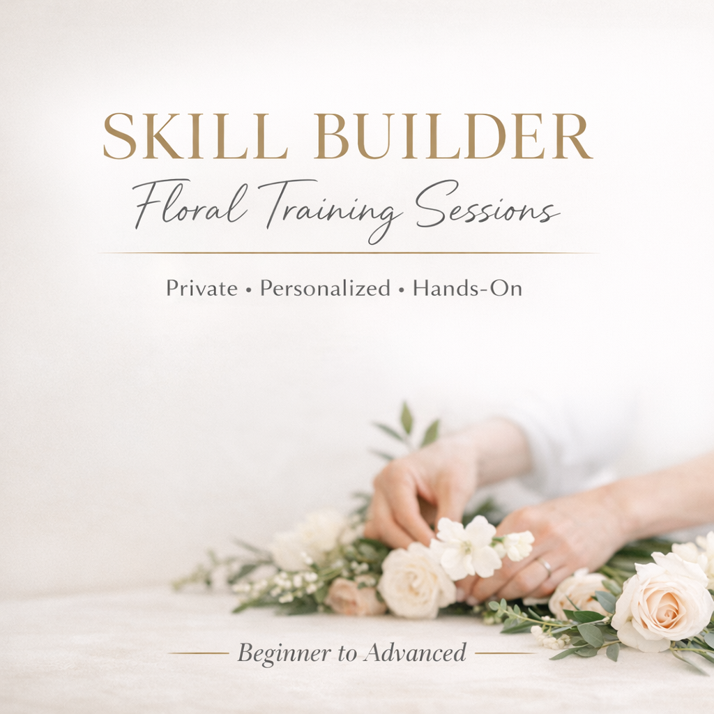 Group of people smiling, holding fall flower arrangements in pumpkins, in a workshop setting.