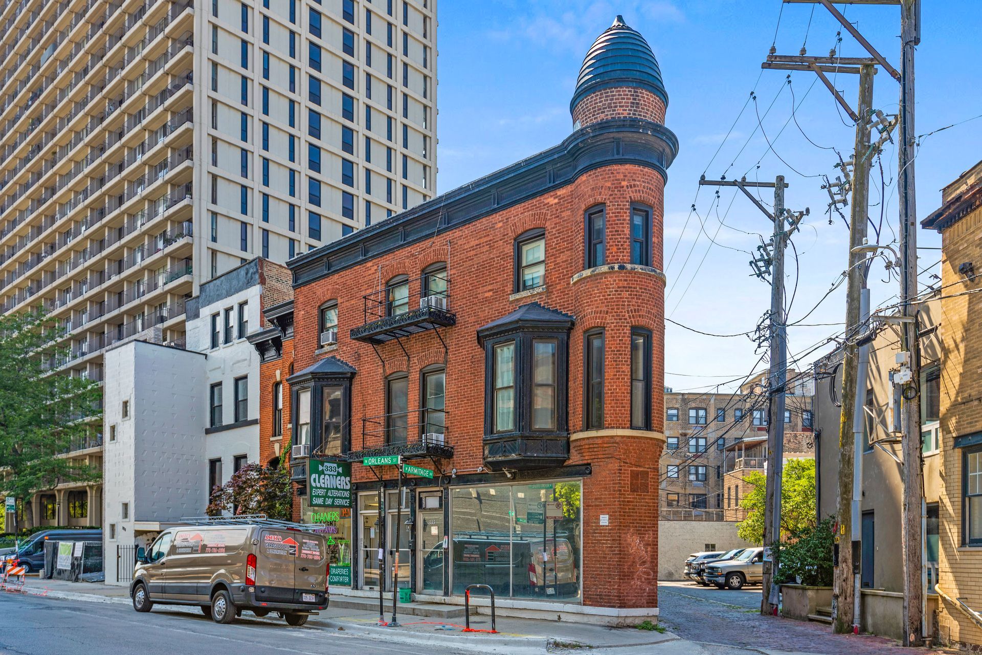A van is parked in front of a brick building in a city.