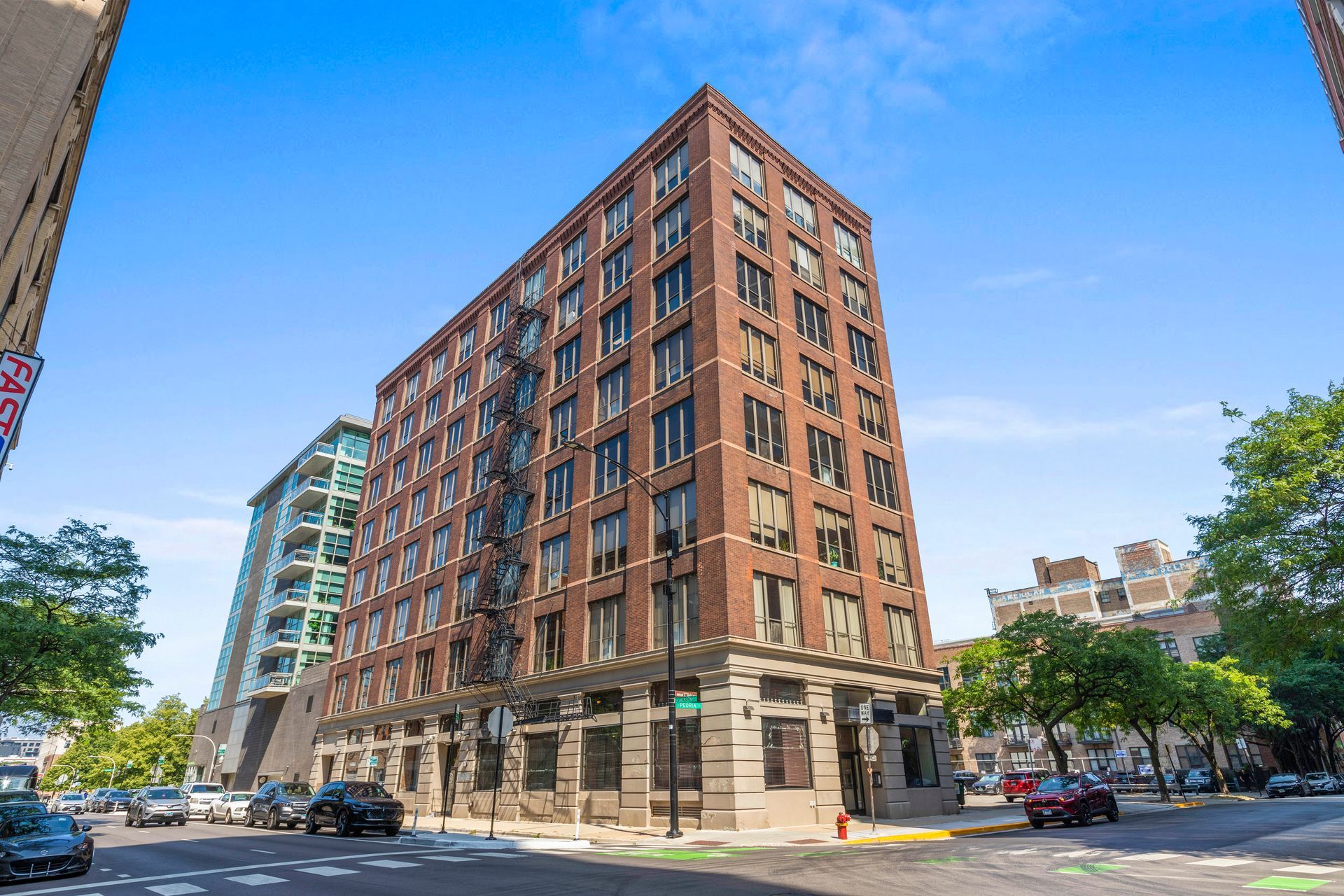 A large brick building is sitting on the corner of a city street.