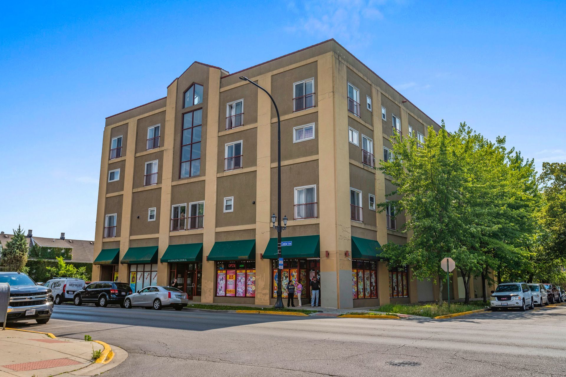 A large building with a lot of windows is sitting on the corner of a street.