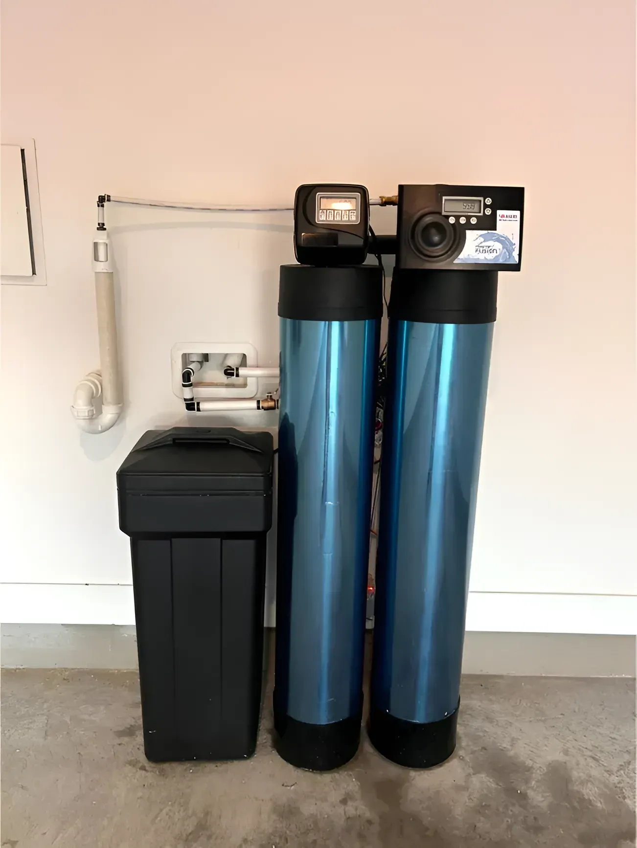 Water filtration system with two blue tanks, a black salt tank, and control panel.