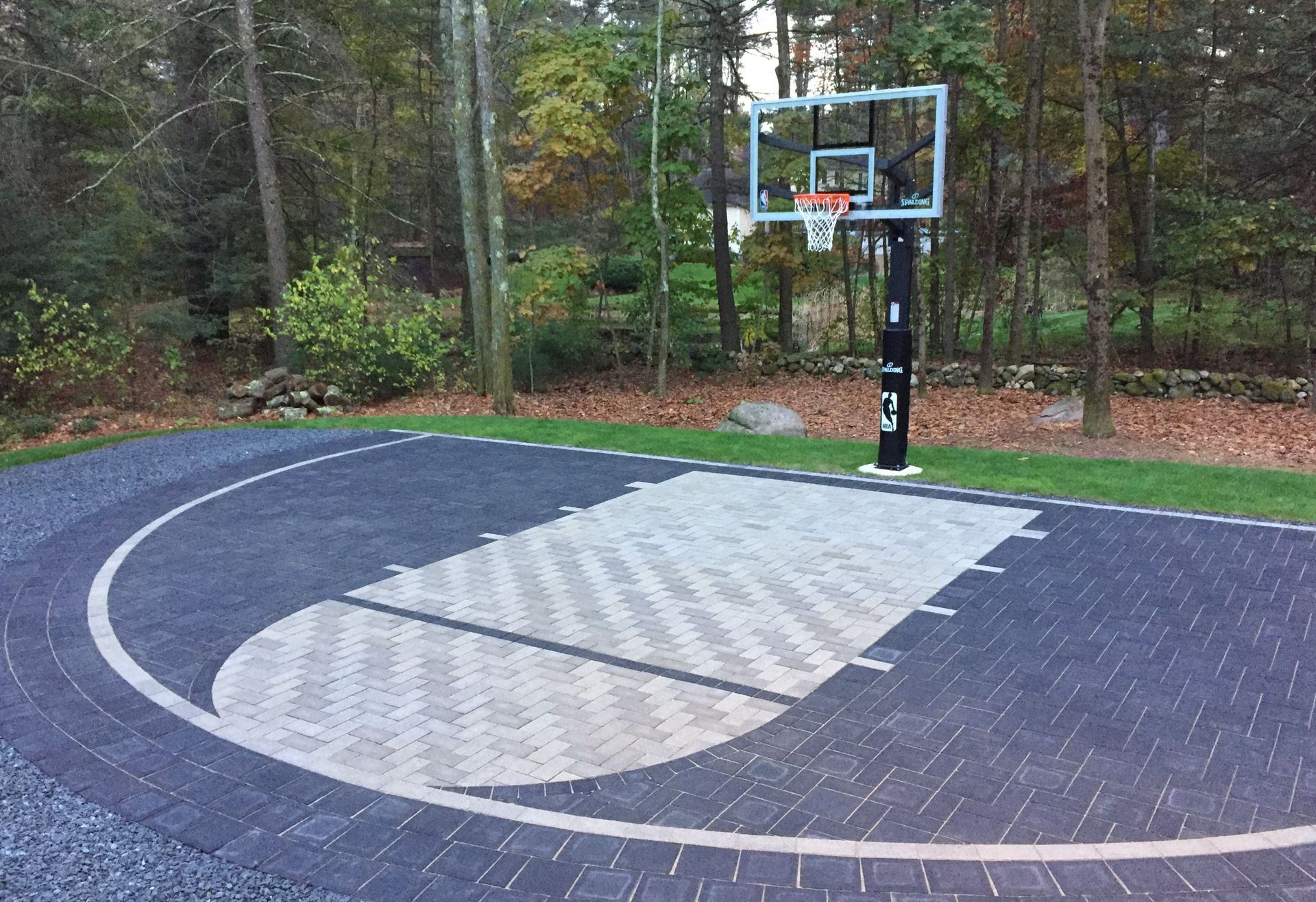 A basketball hoop is in the middle of a driveway