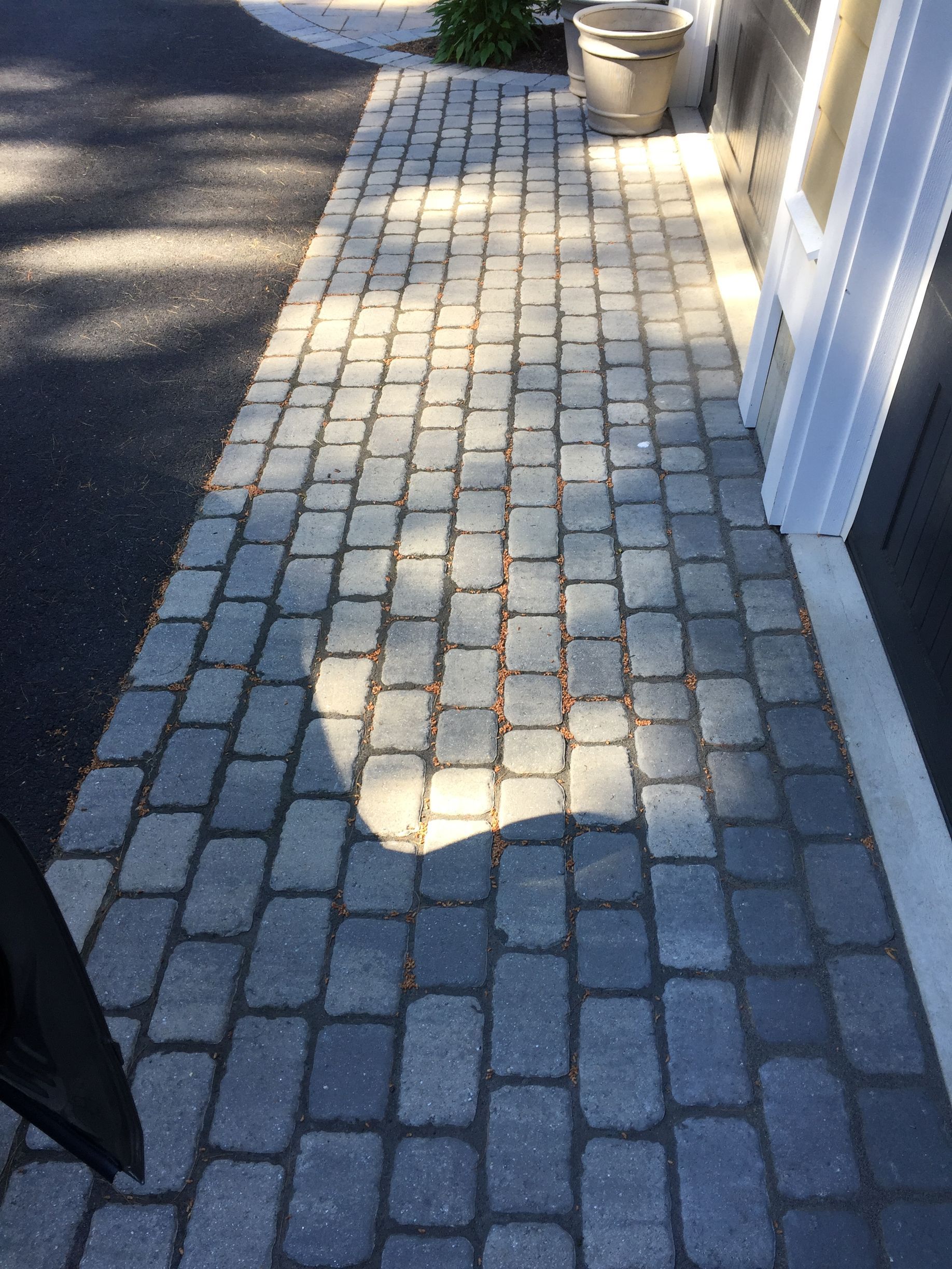 A brick walkway leading to a garage door