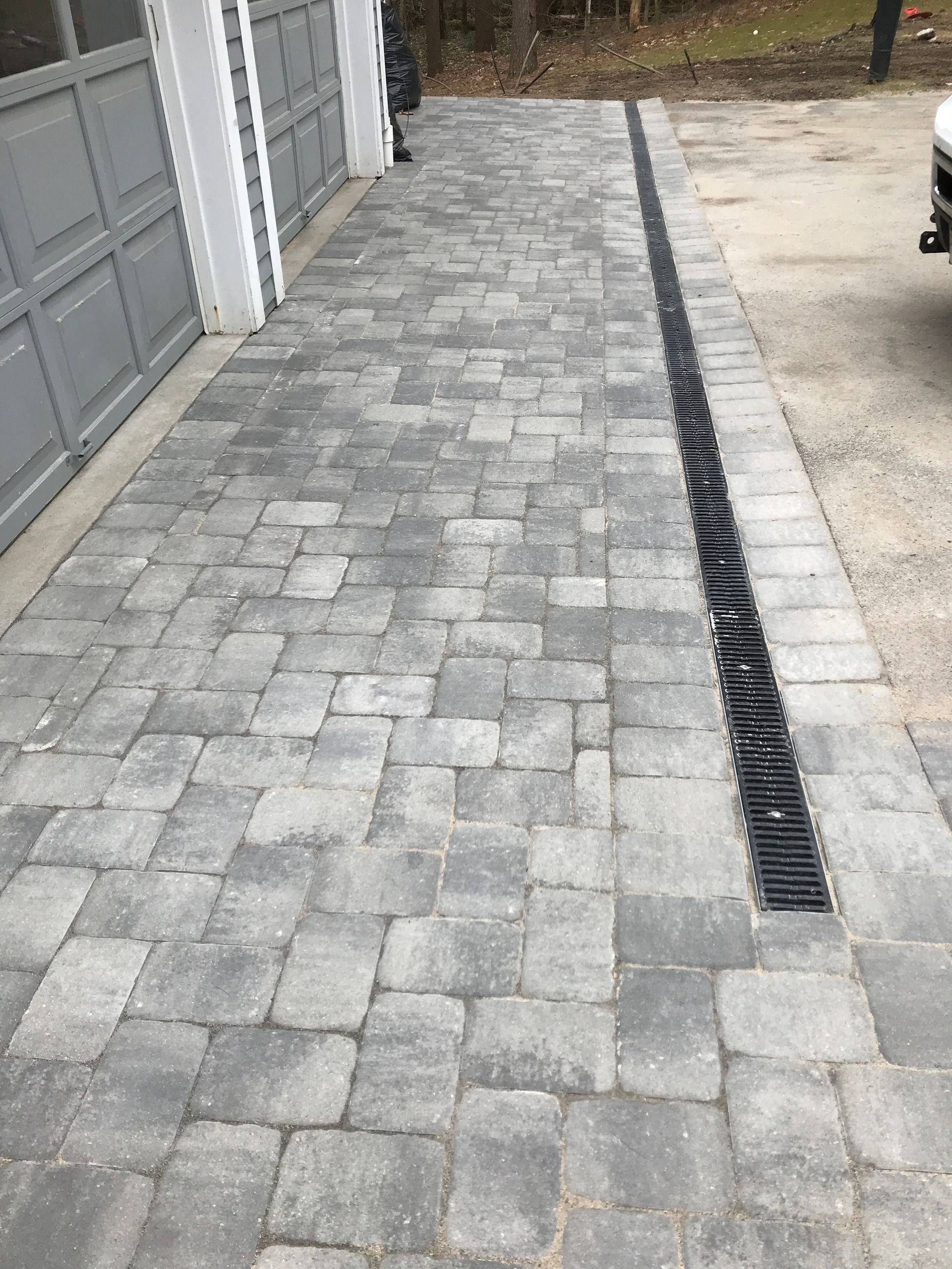 A brick driveway is being built in front of a house