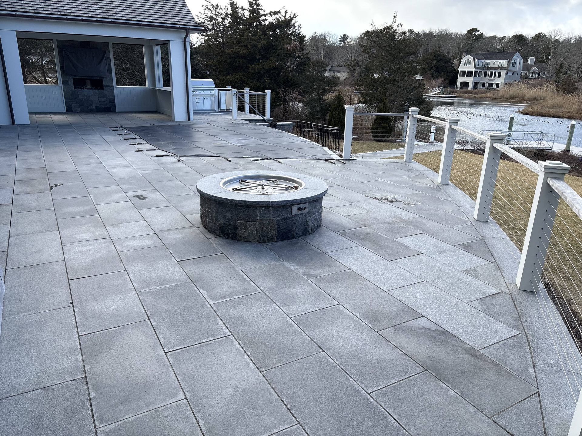 A fire pit is sitting on a patio next to a house.