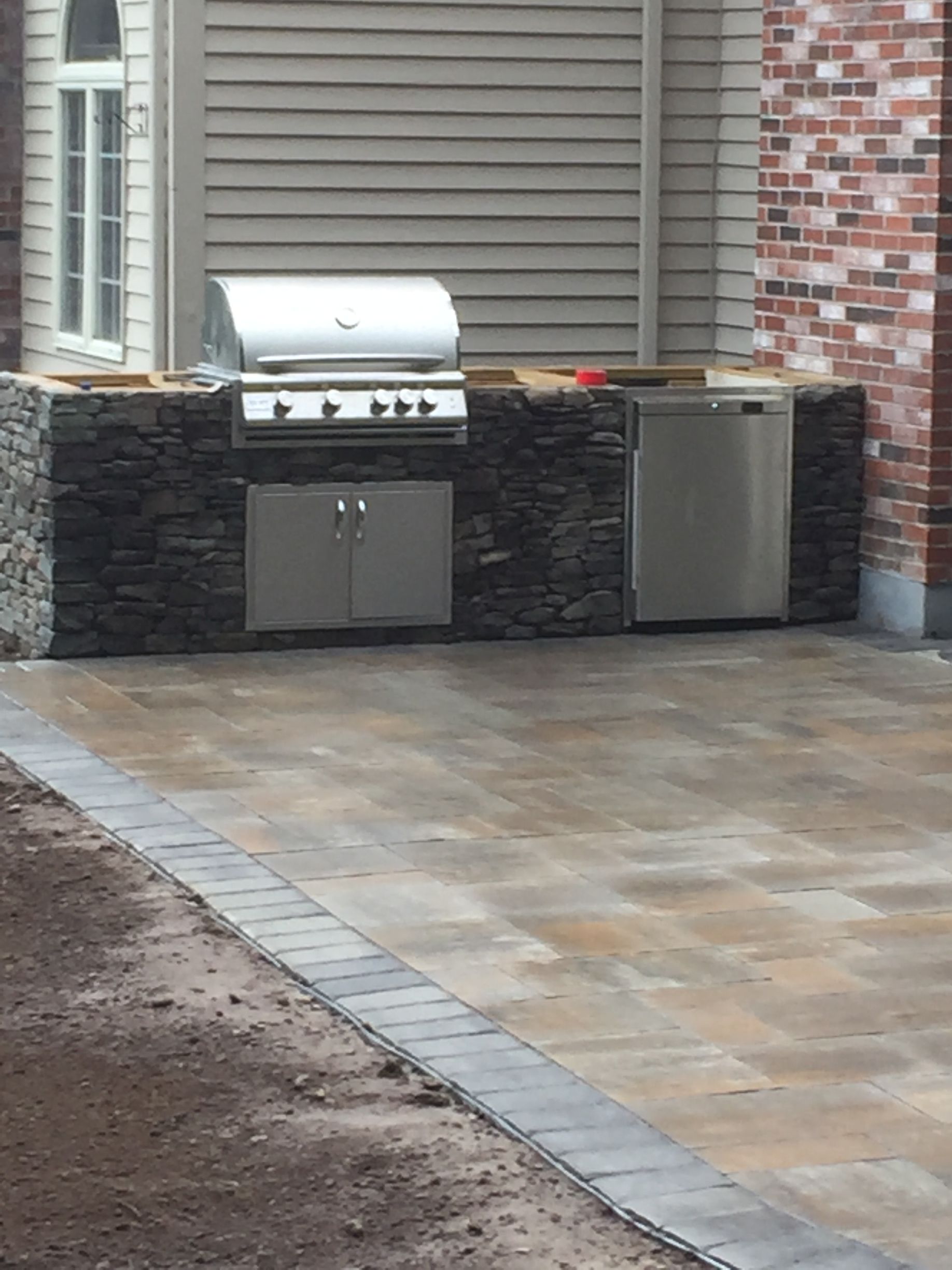 There is a grill and a dishwasher in the backyard.