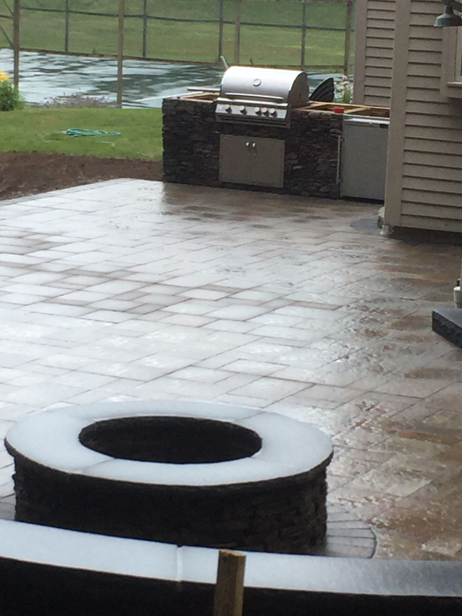 A patio with a fire pit and a grill