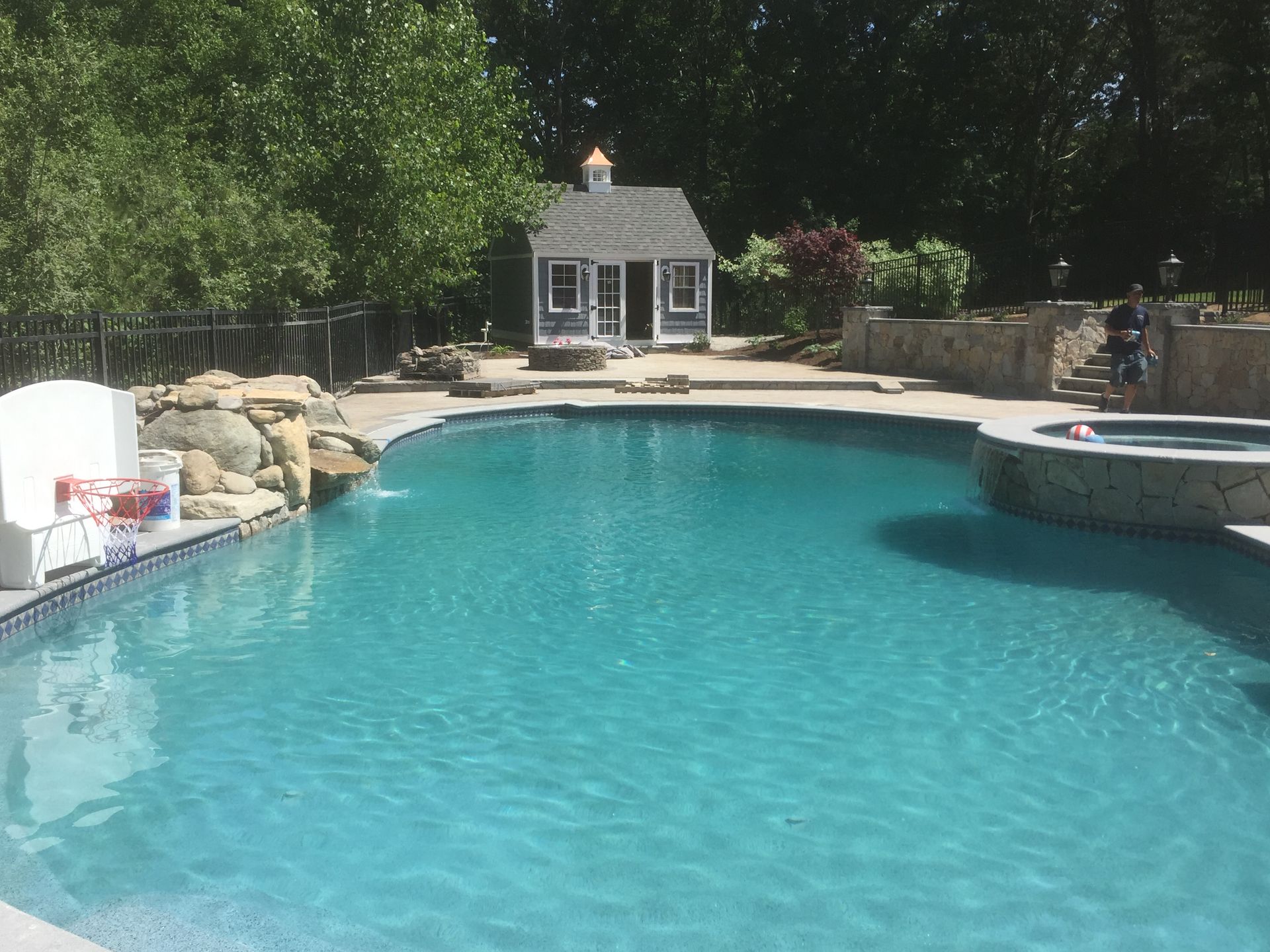 A large swimming pool with a house in the background