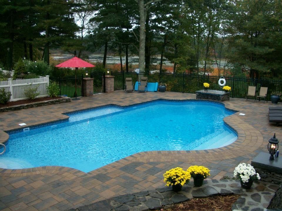 A large swimming pool with a red umbrella in the background