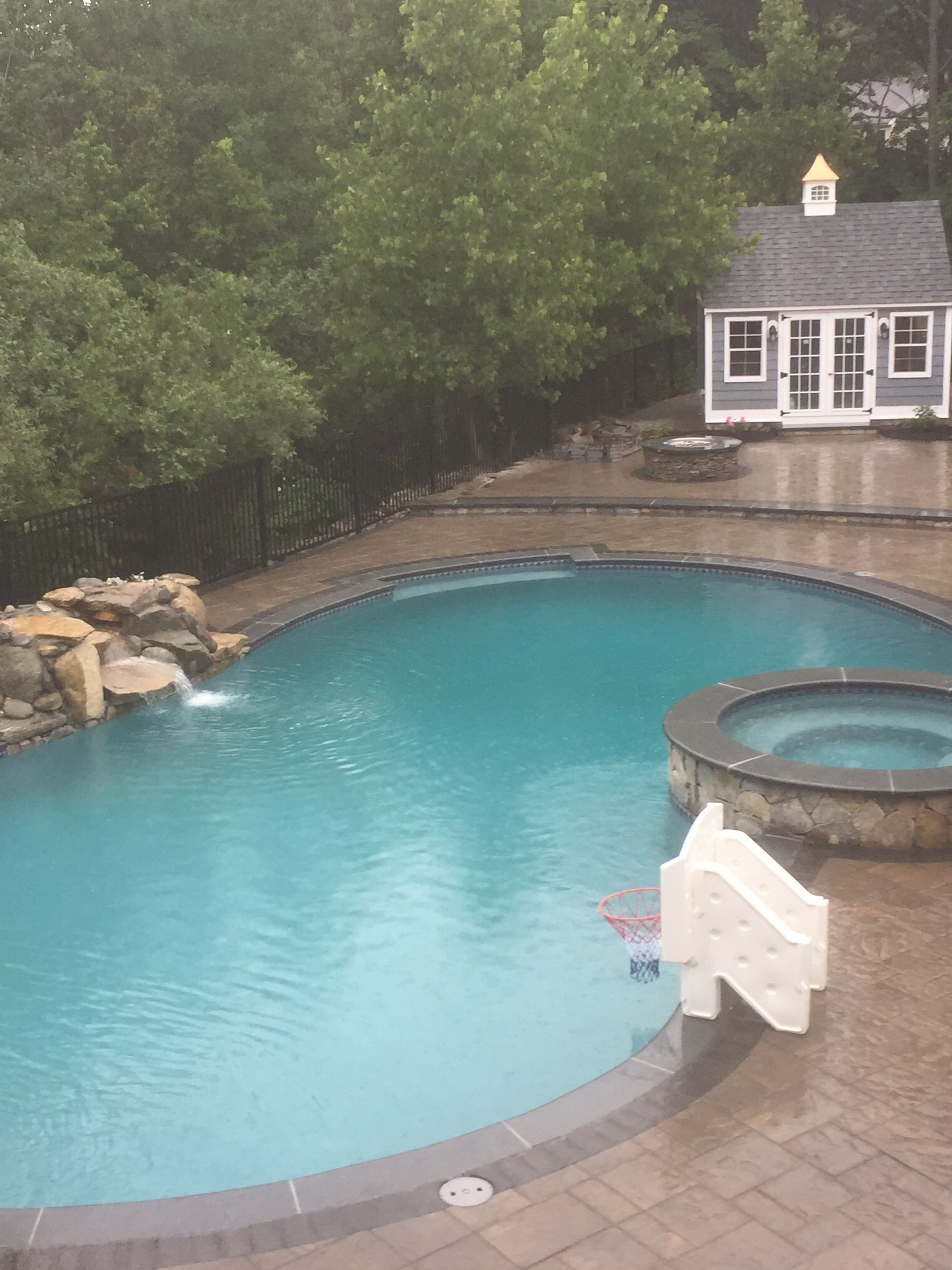 A large swimming pool with a house in the background
