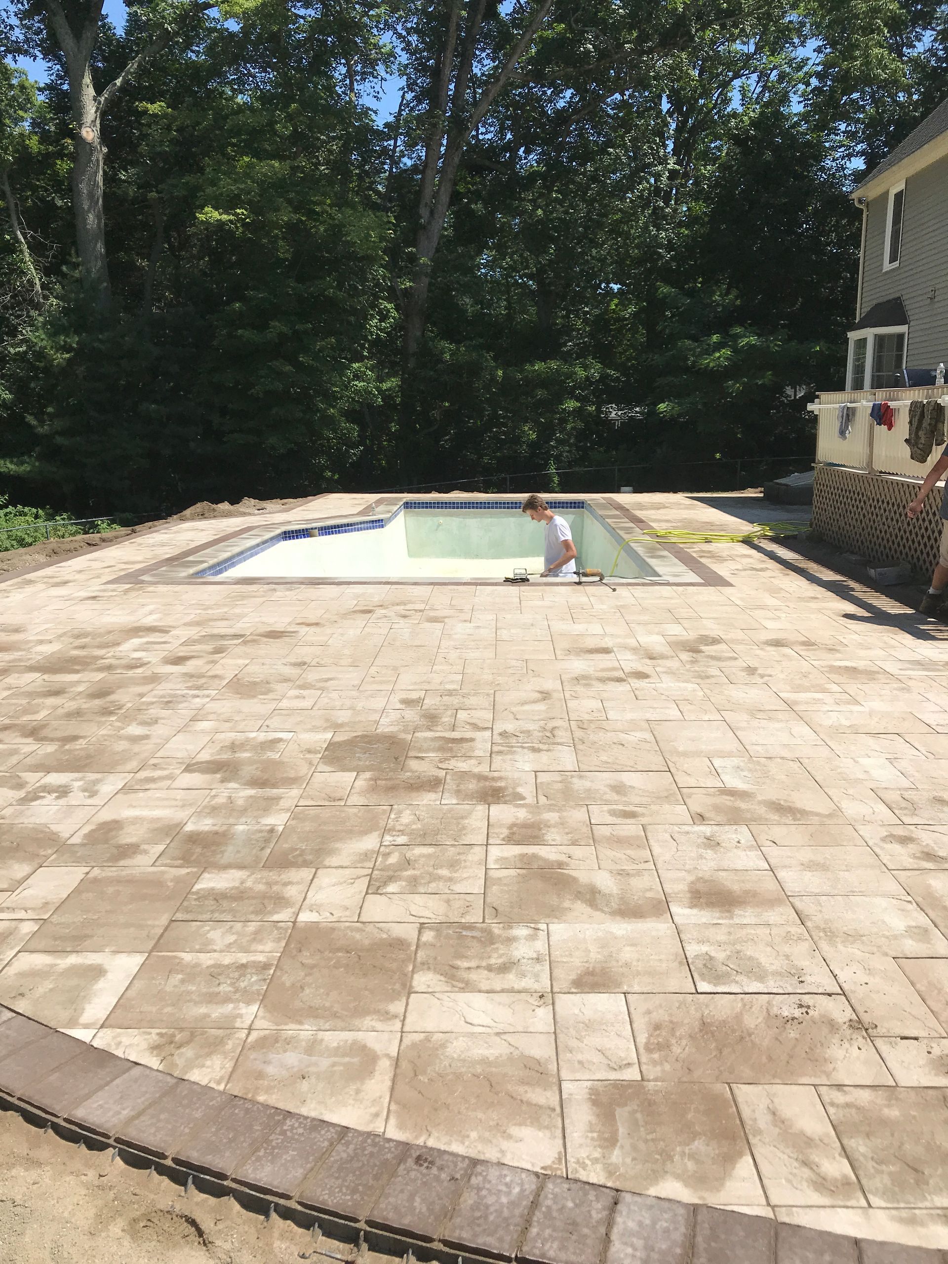 A patio with a swimming pool in the background