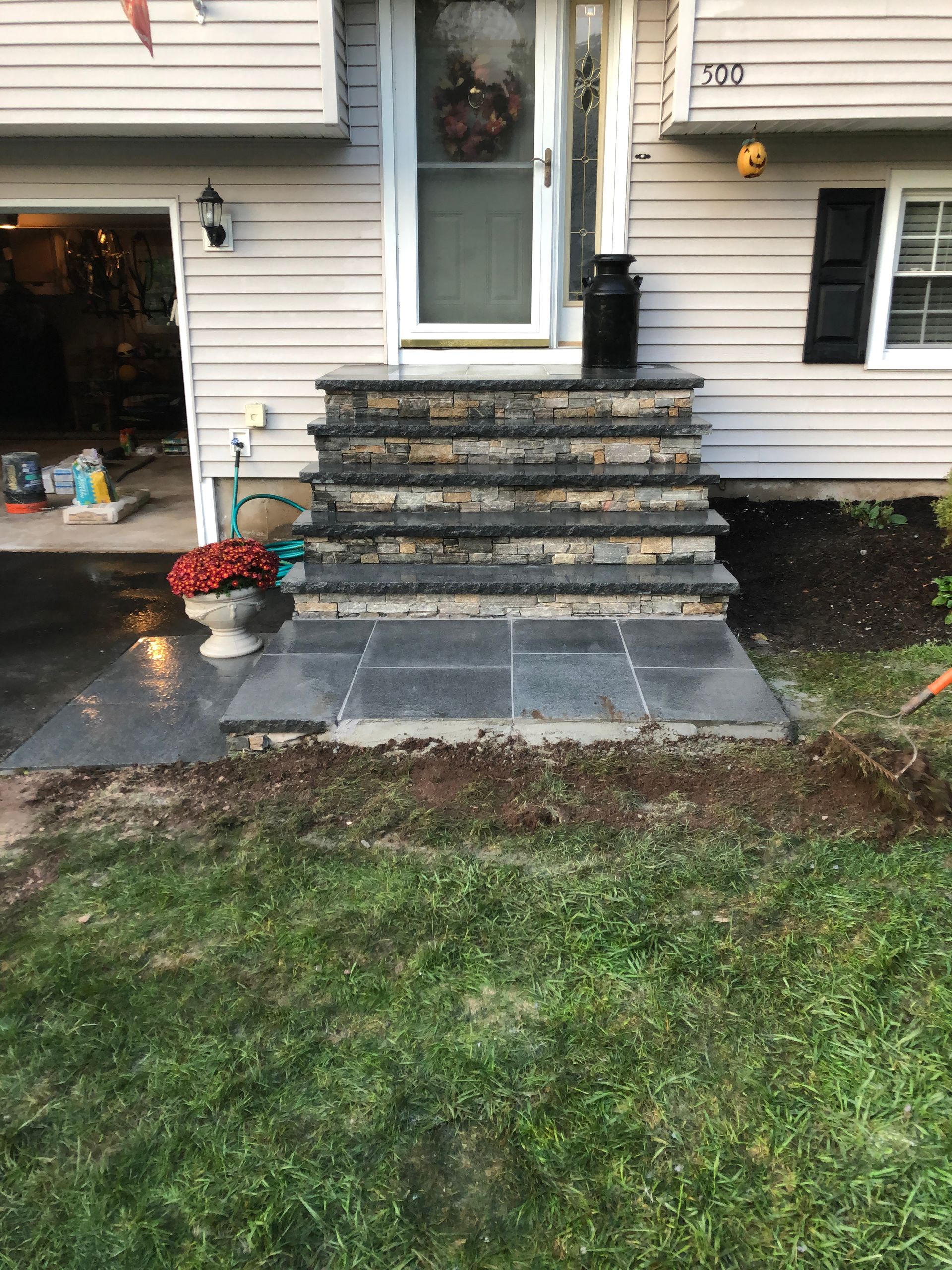 A house with a patio and stairs in front of it.