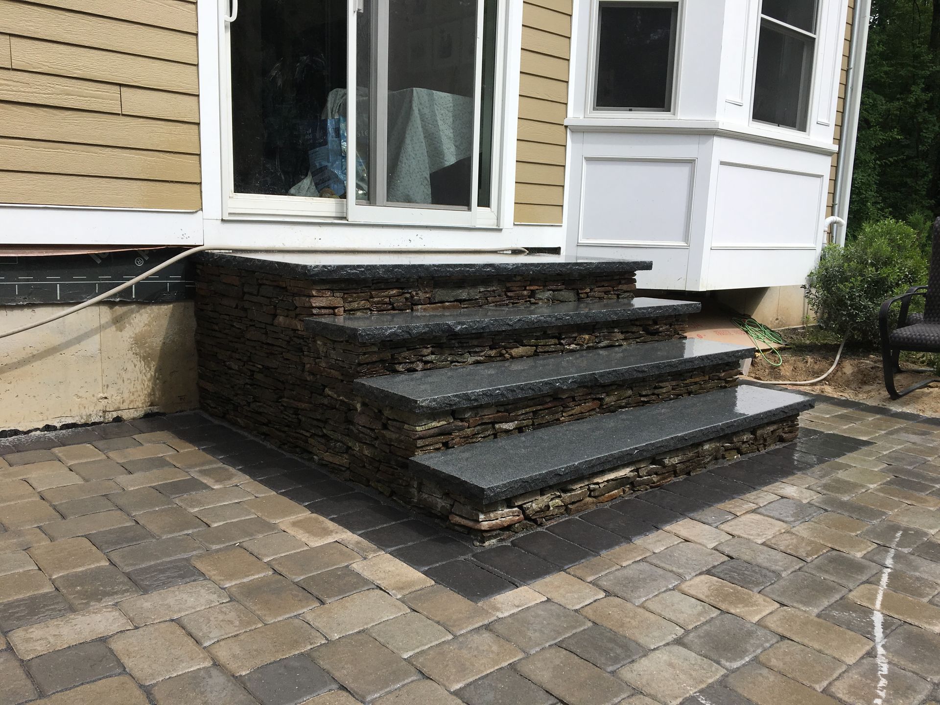 A set of stairs leading up to a house on a brick patio.