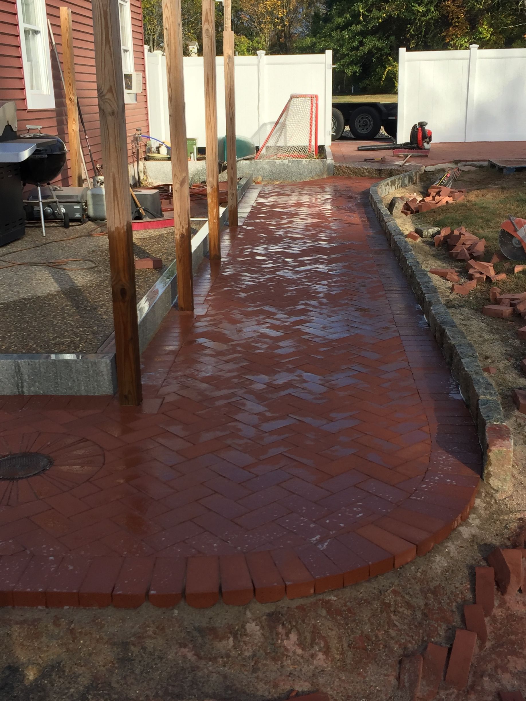A brick walkway is being built in front of a house.