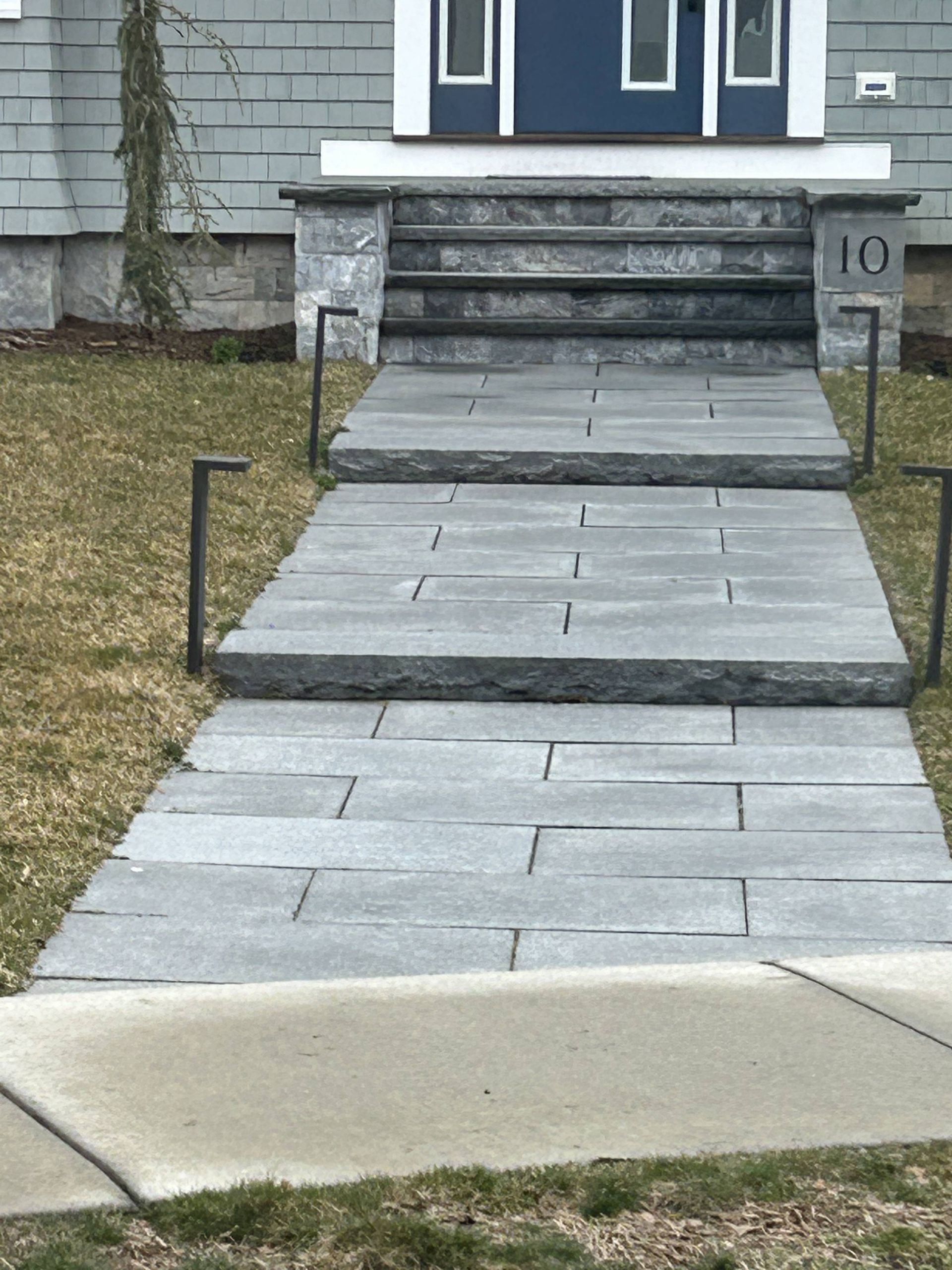 A stone walkway leading to the front door of a house