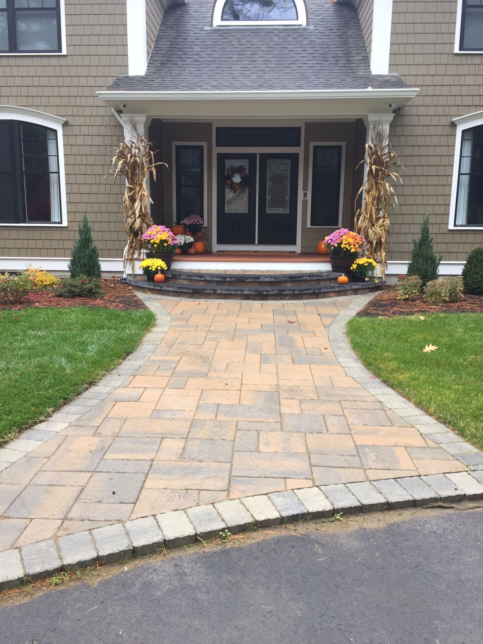A brick walkway leading to the front door of a house.