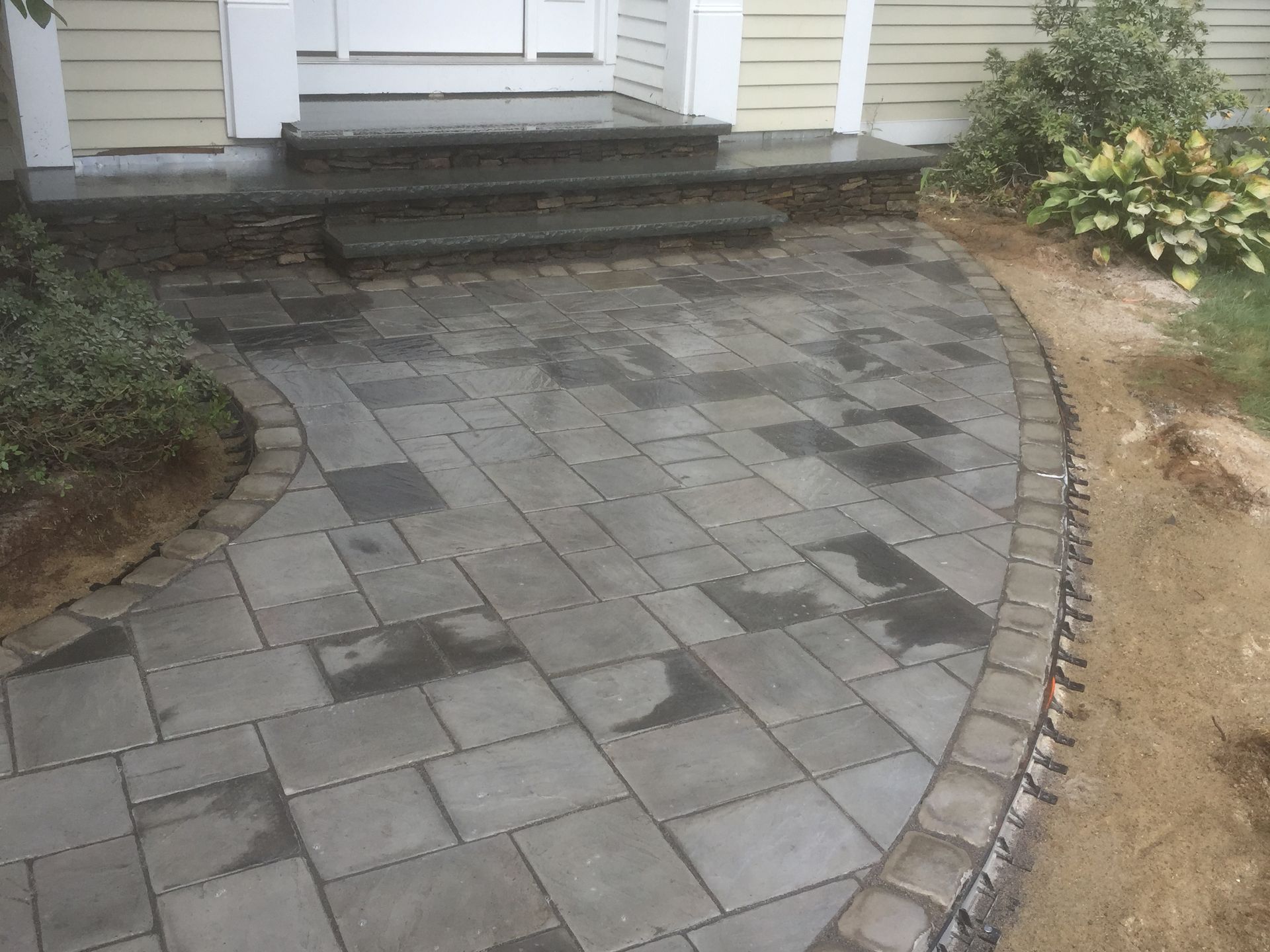 A brick walkway leading to the front door of a house