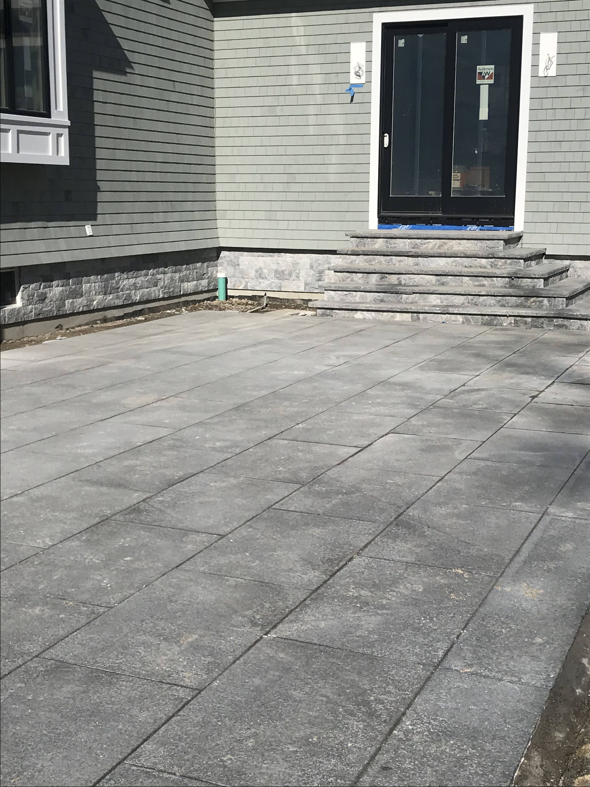 A patio in front of a house with a sliding glass door