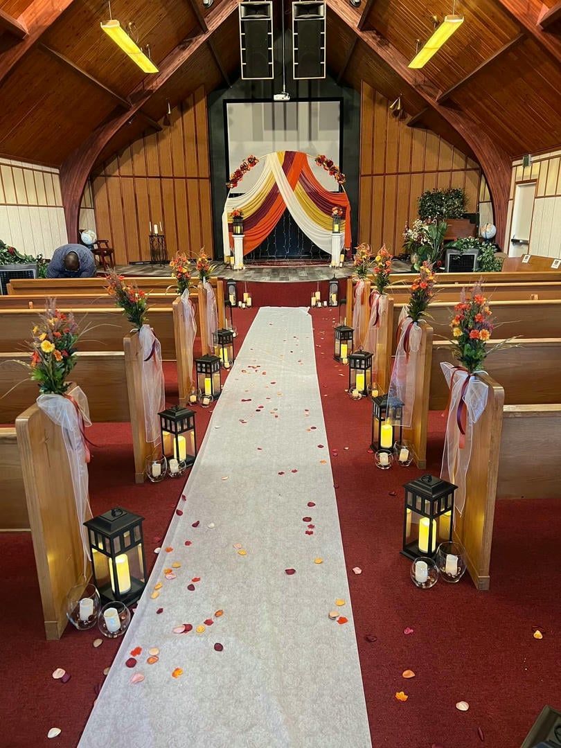 A church is decorated for a wedding with candles and flowers