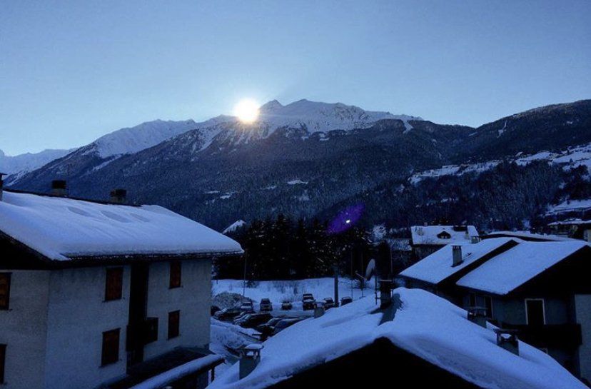 Il sole splende attraverso le montagne sullo sfondo