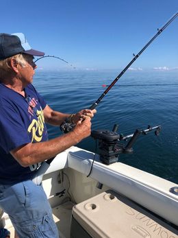 A man is fishing on a boat in the ocean.