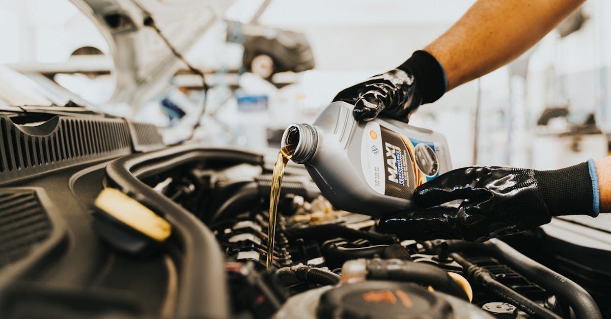 A person is pouring oil into a car engine.