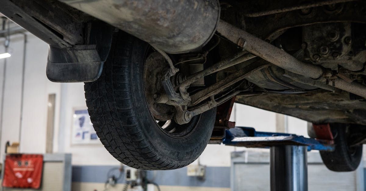 A car is sitting on a lift in a garage.