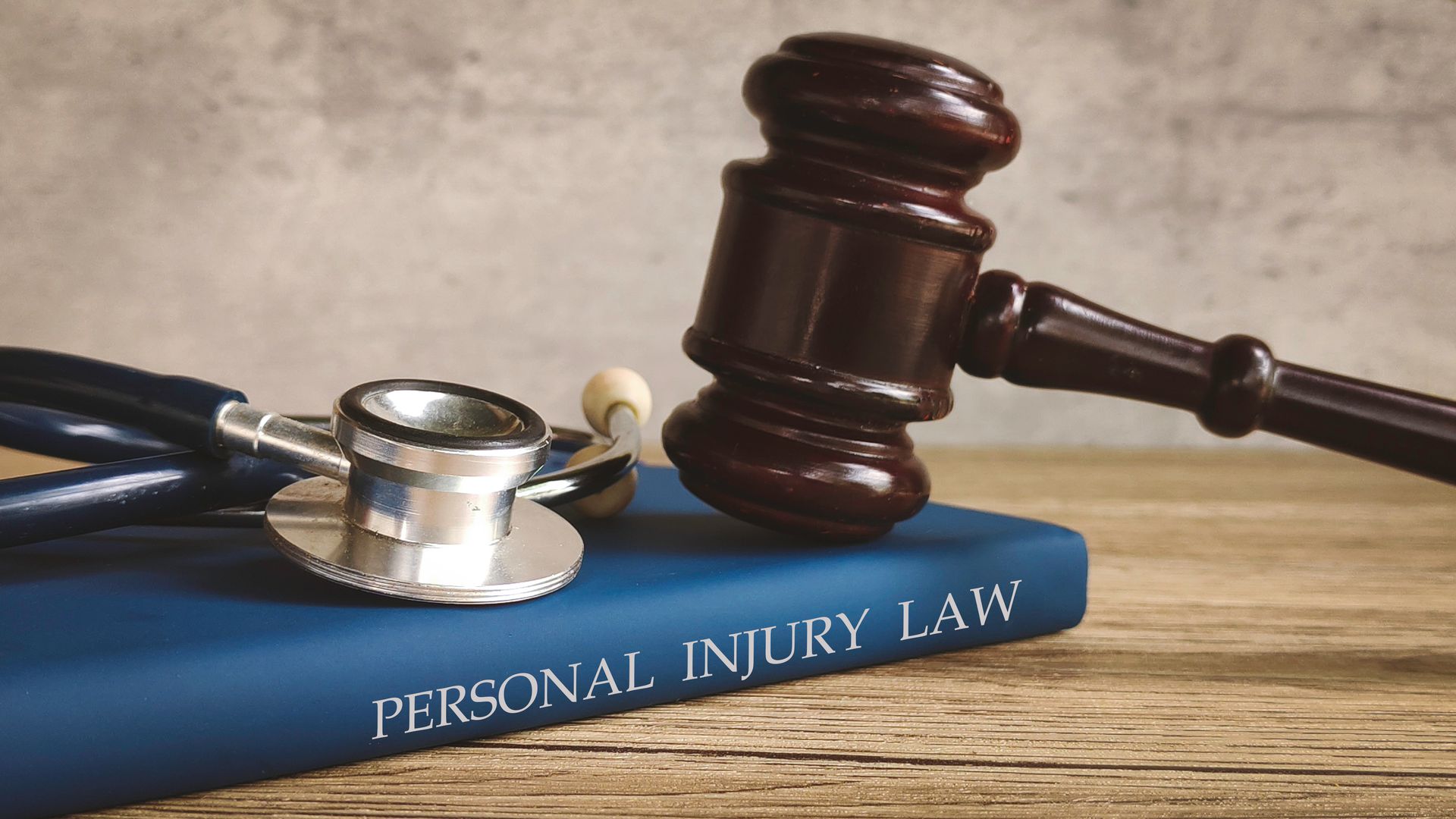 Gavel and stethoscope on injury law book, symbolizing justice and medical accountability.
