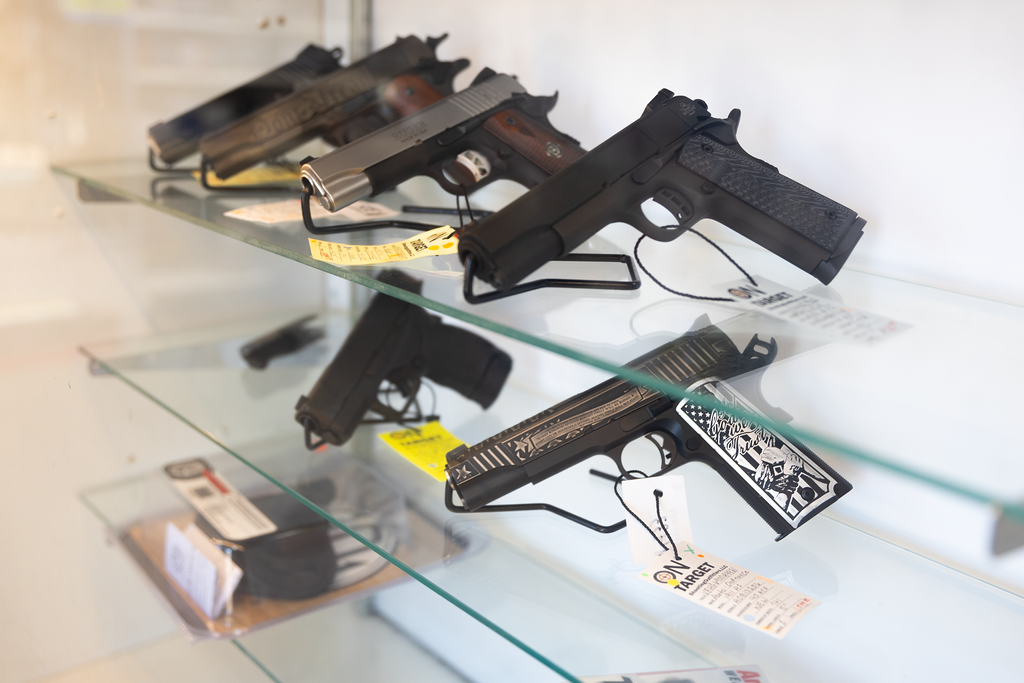 A glass shelf with customized handguns