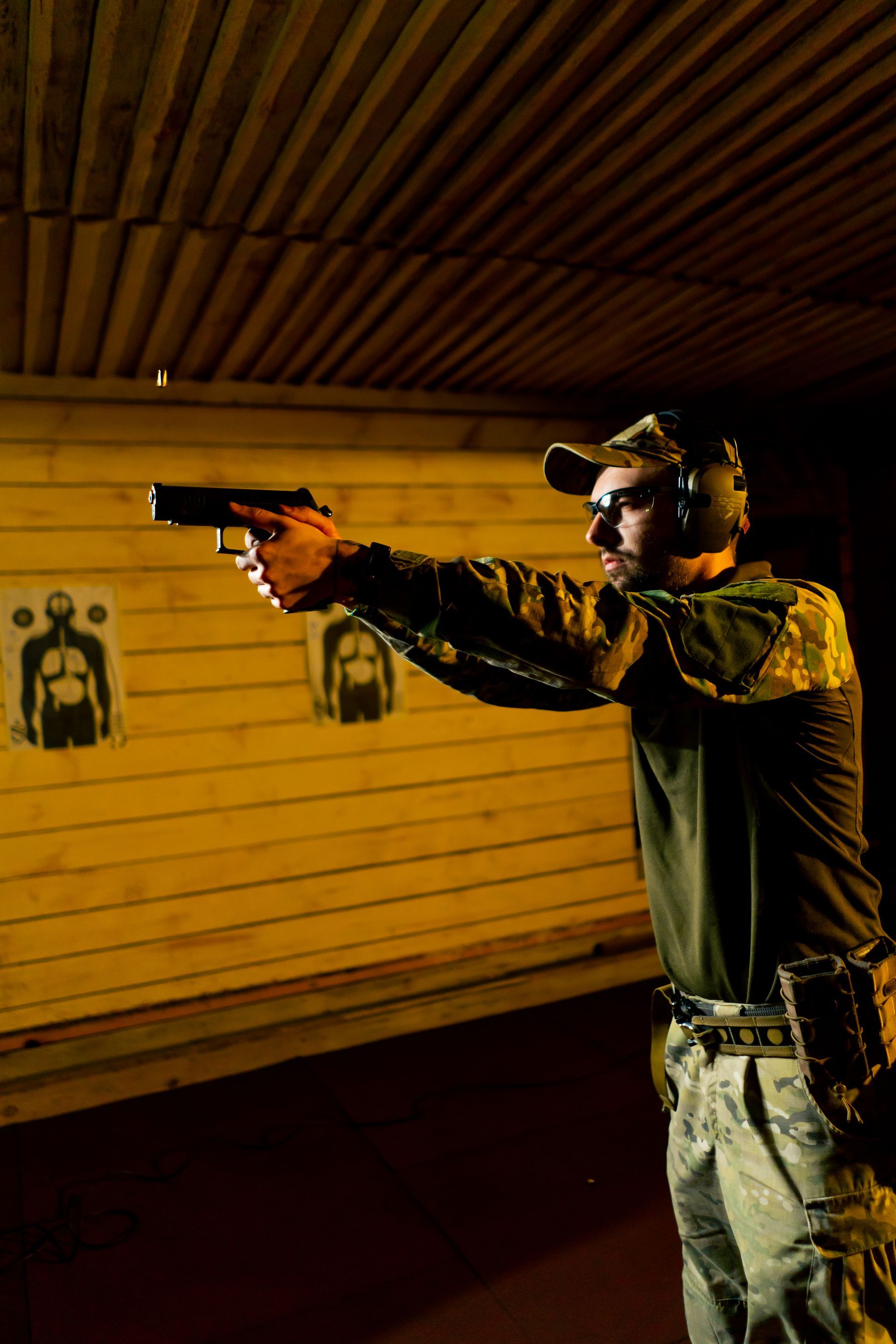 A man holds a pistol in a firing position