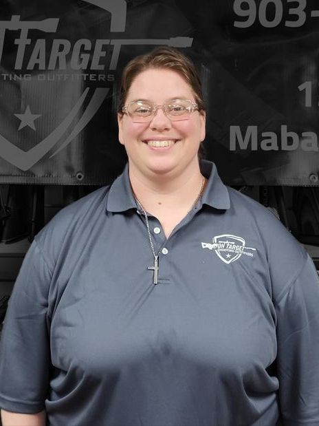 A woman is smiling in front of a target sign