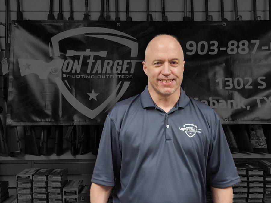 A man standing in front of a sign that says on target