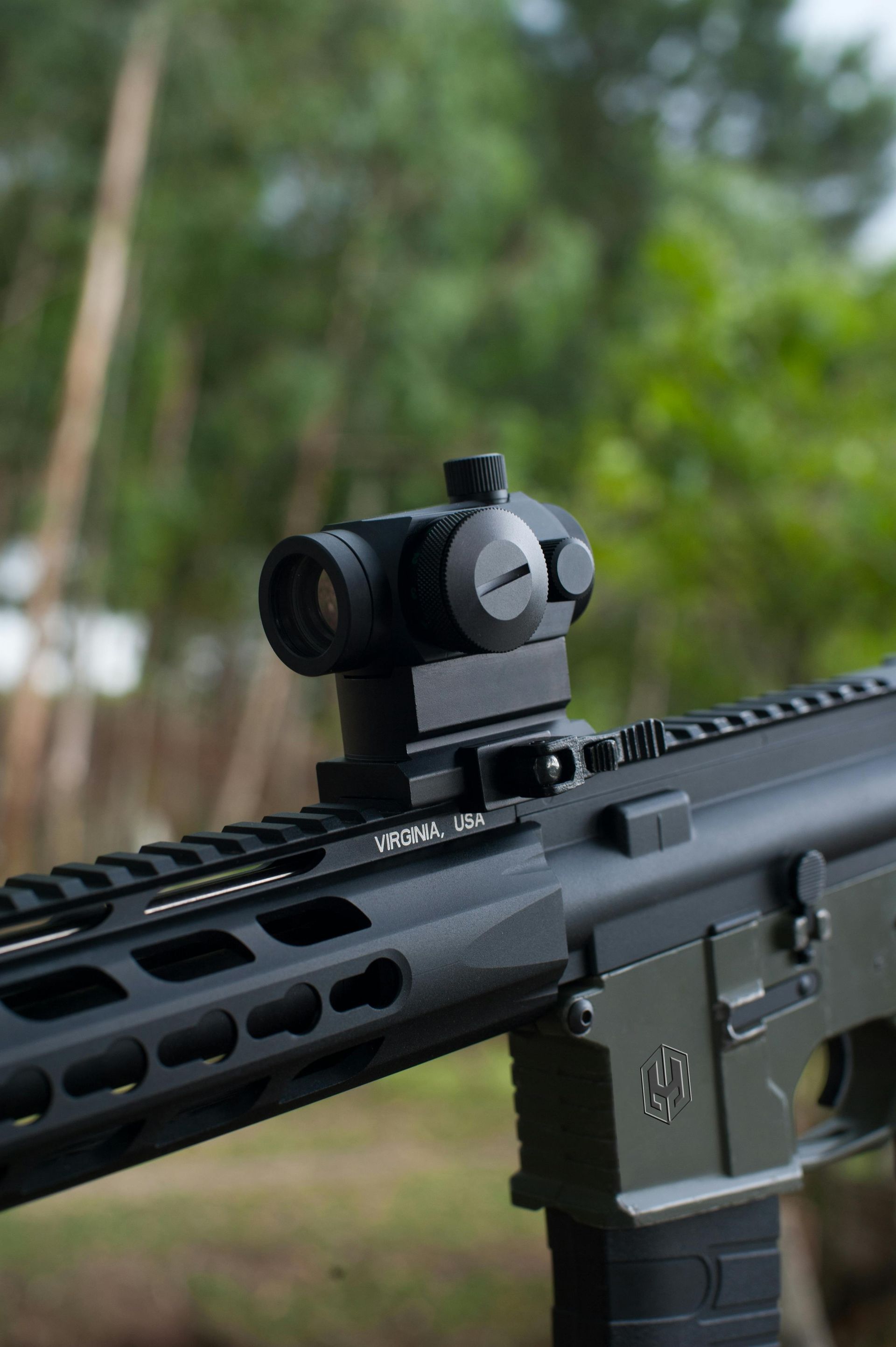 A rifle with a red dot sight attached