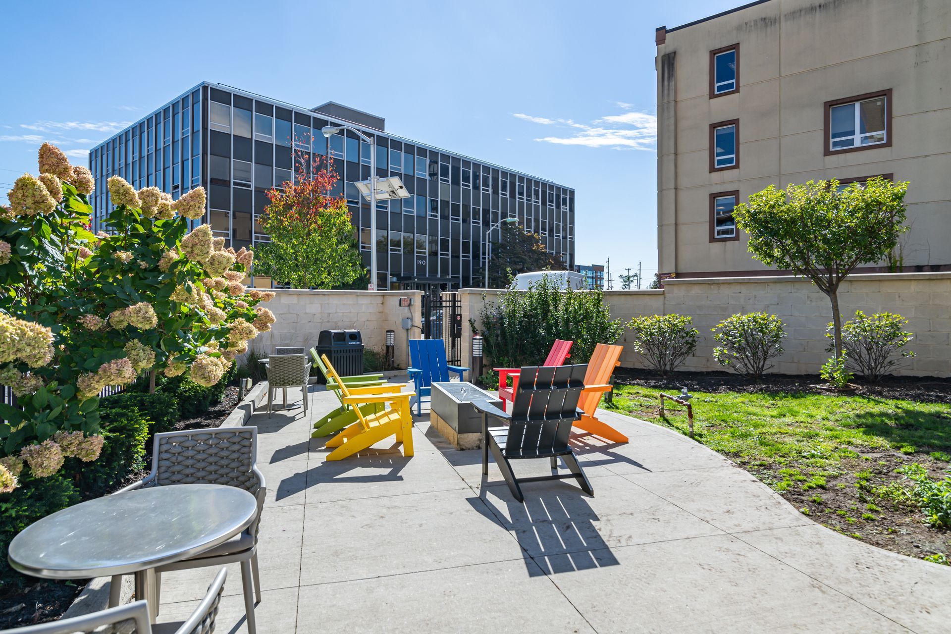 A patio with a table and chairs in front of a building.