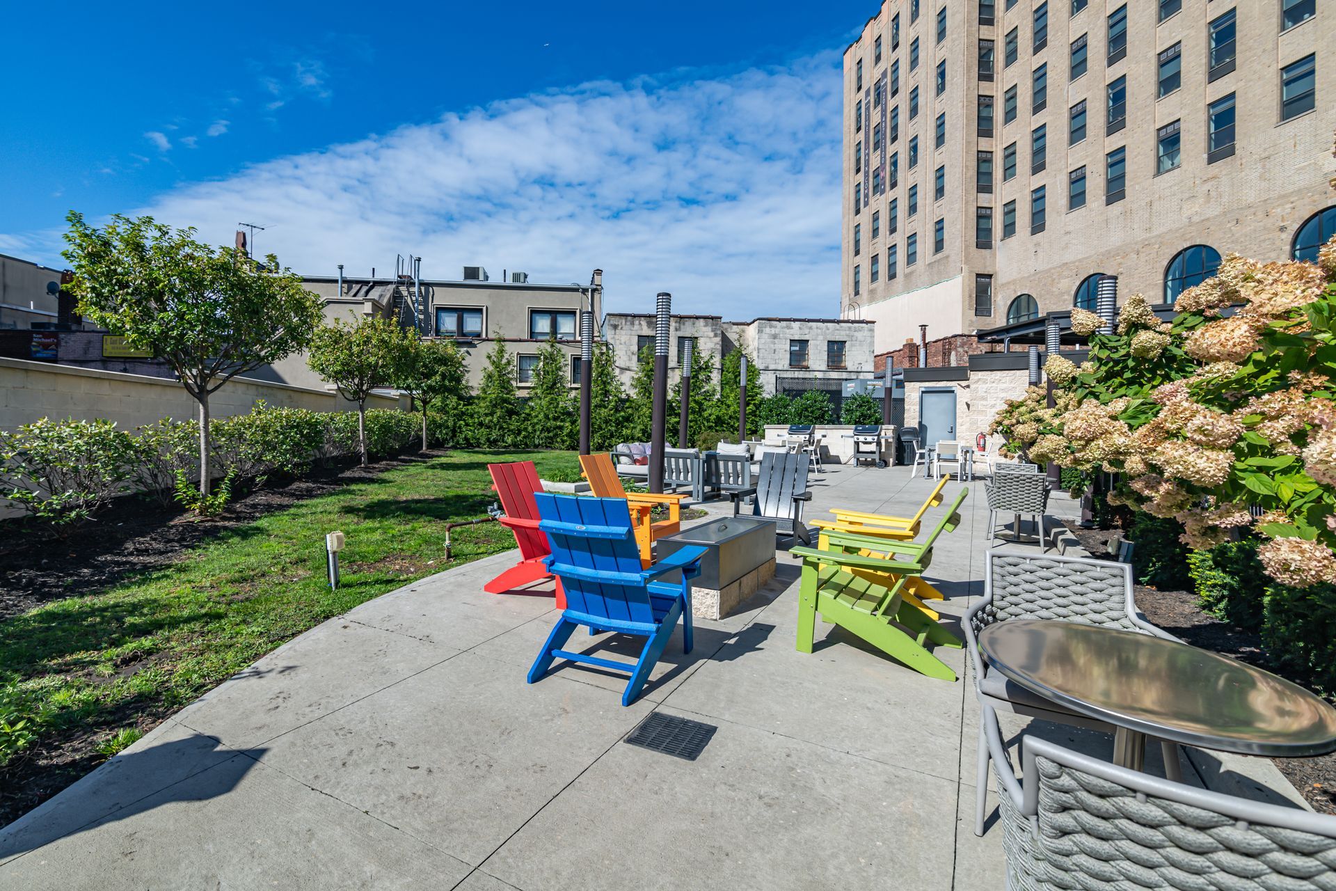 A row of colorful chairs are sitting on a patio in front of a building.