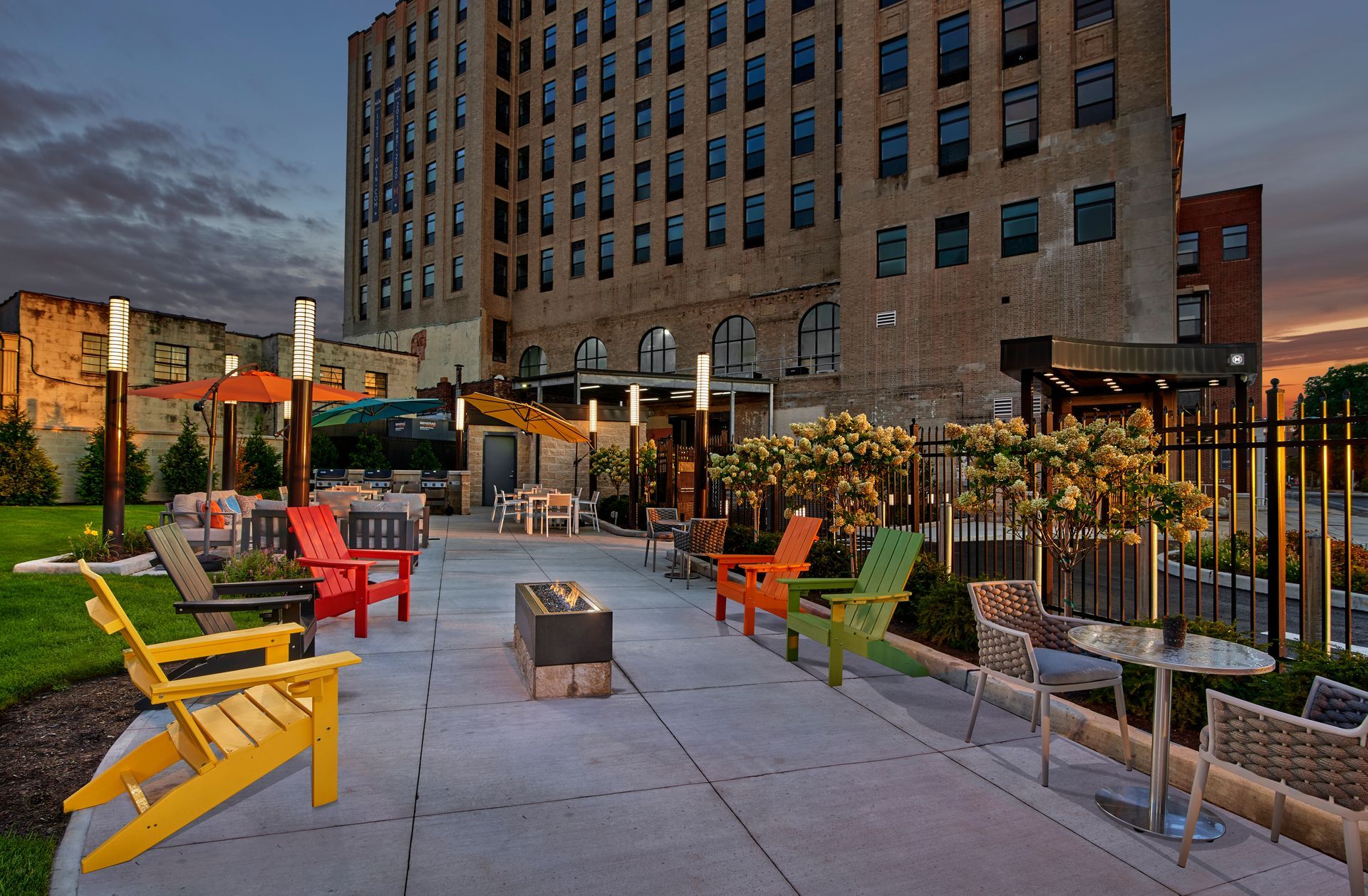 A patio area with chairs and tables in front of a large building