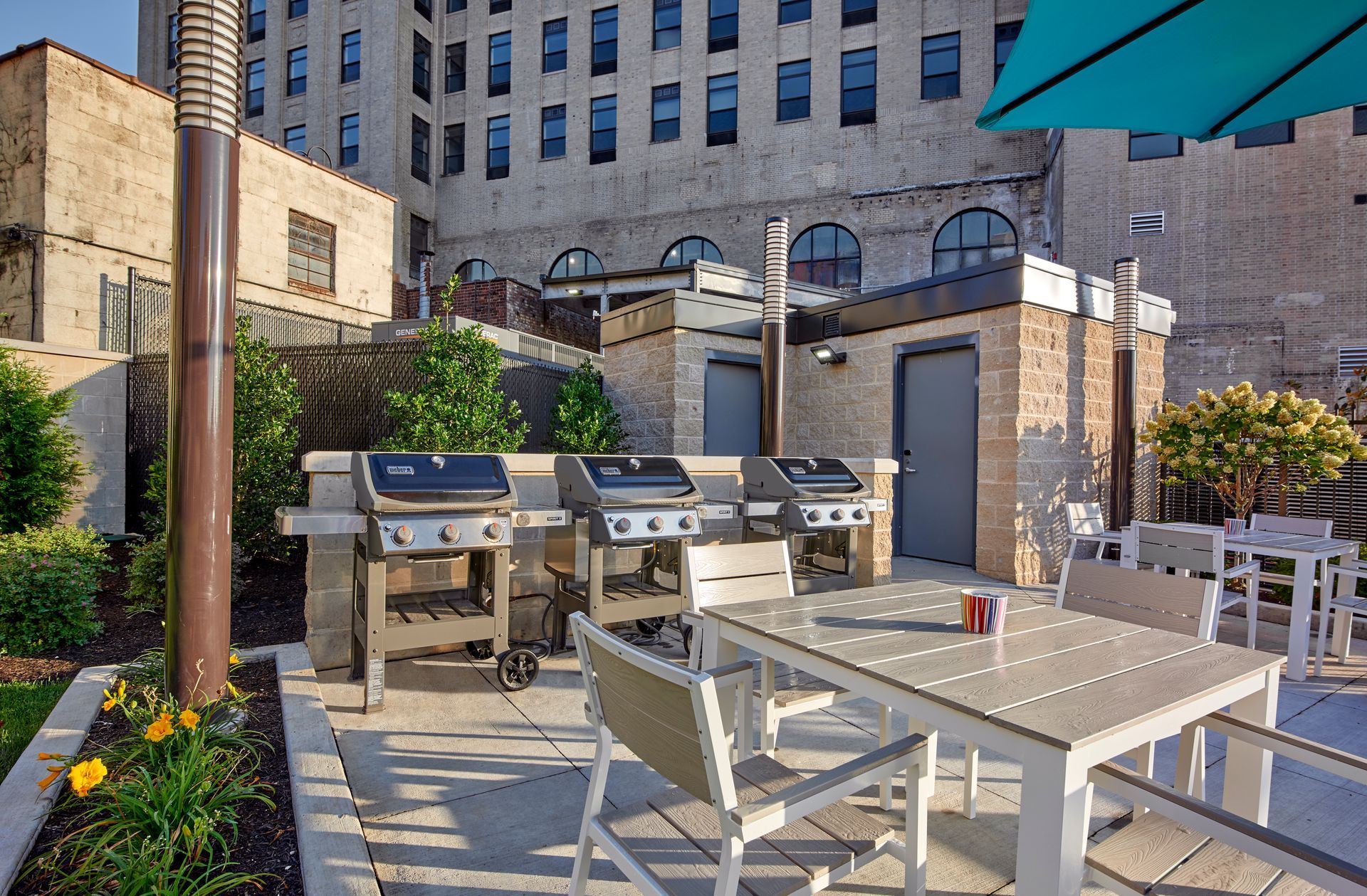 A patio with a table and chairs and grills in front of a building