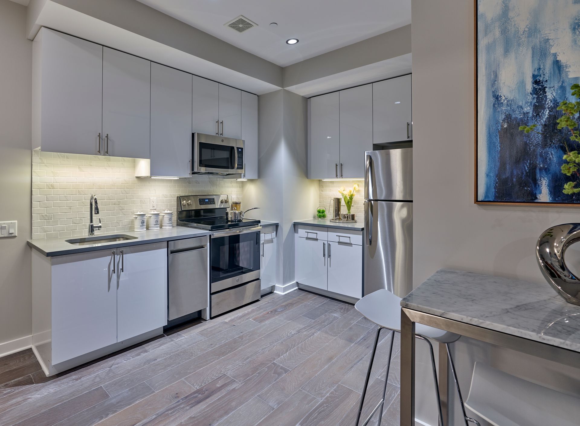 A kitchen with stainless steel appliances and white cabinets