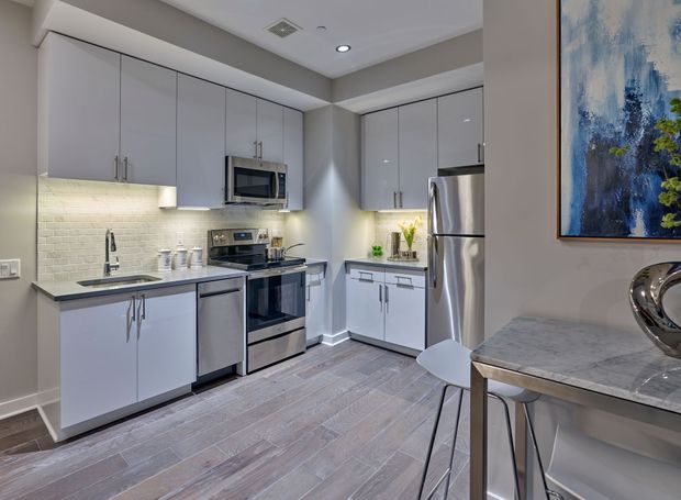 A kitchen with stainless steel appliances and white cabinets