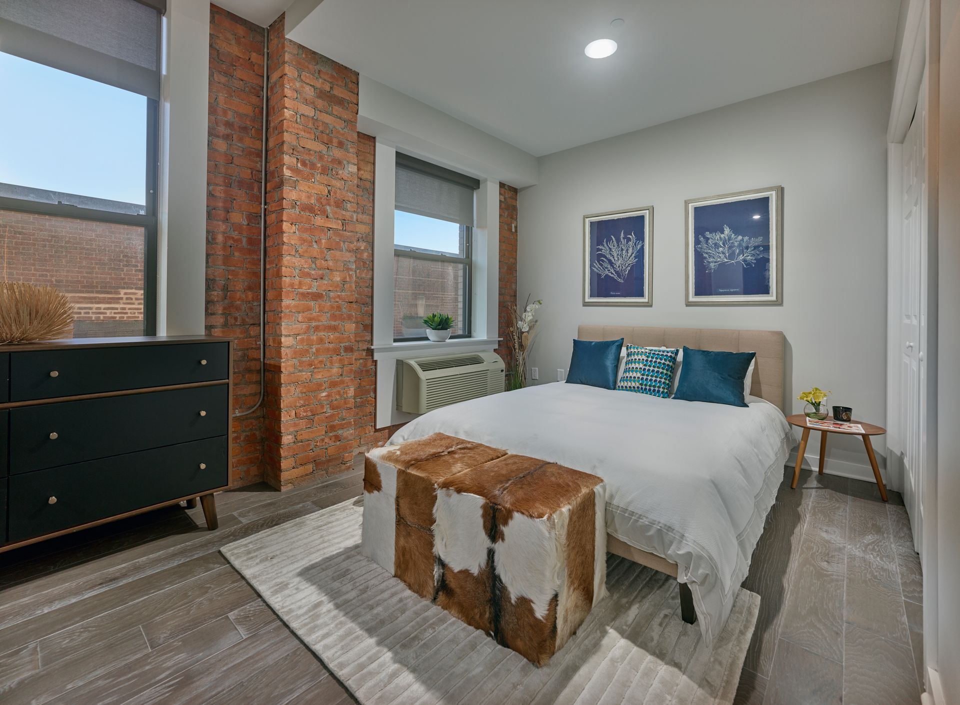 A bedroom with a bed , dresser , and window.