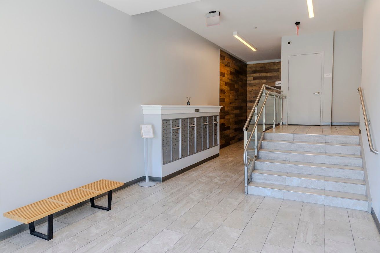 A lobby with a bench and stairs in a building.