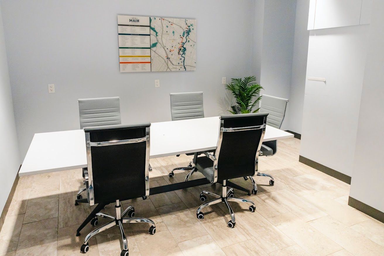 A conference room with a long table and chairs.