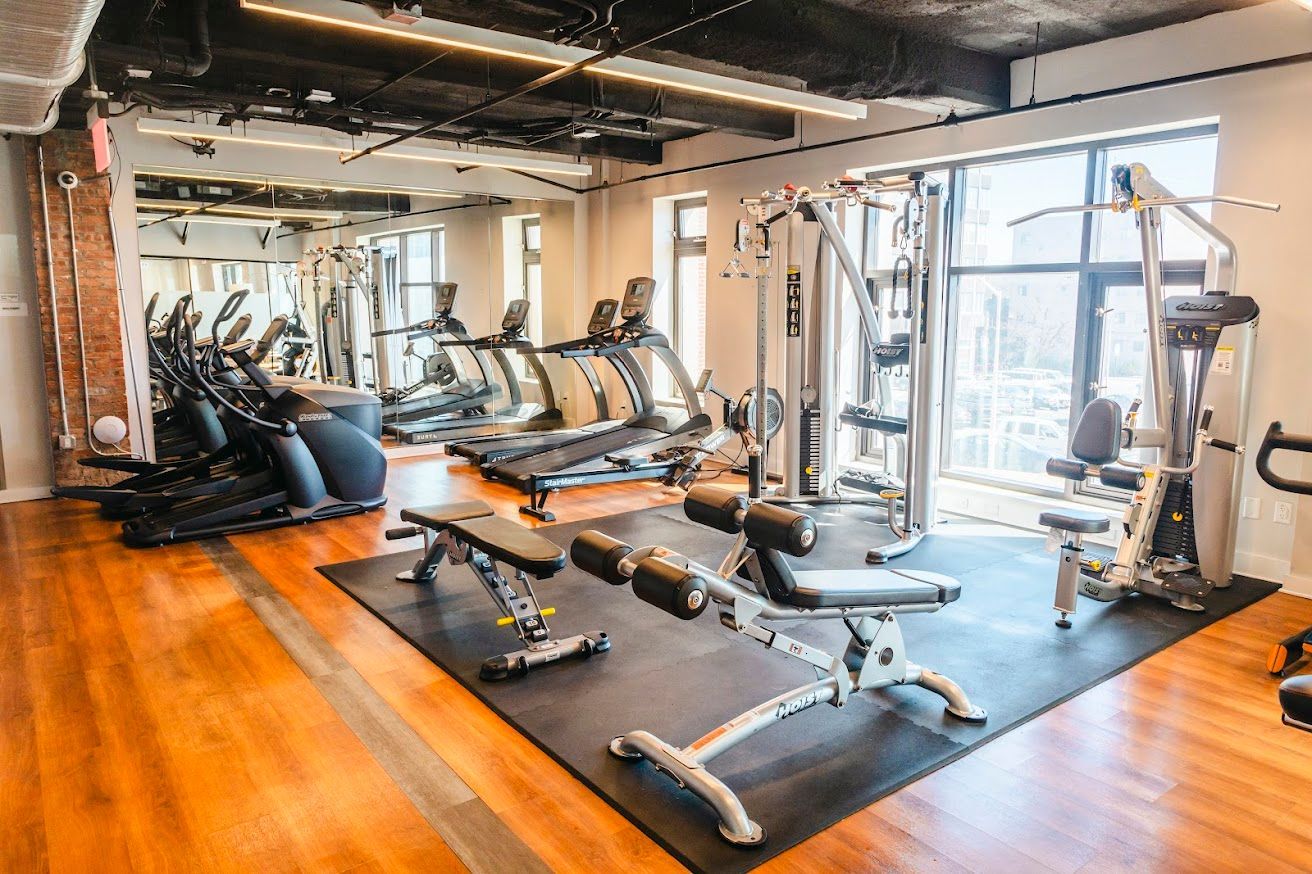A large gym filled with lots of exercise equipment.