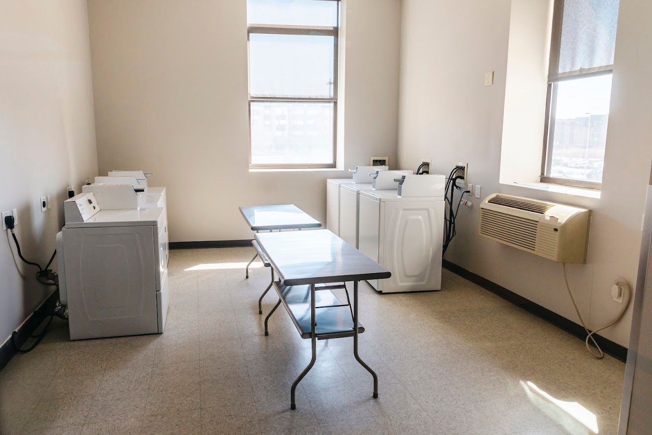 A laundry room with a table , washers and dryers.