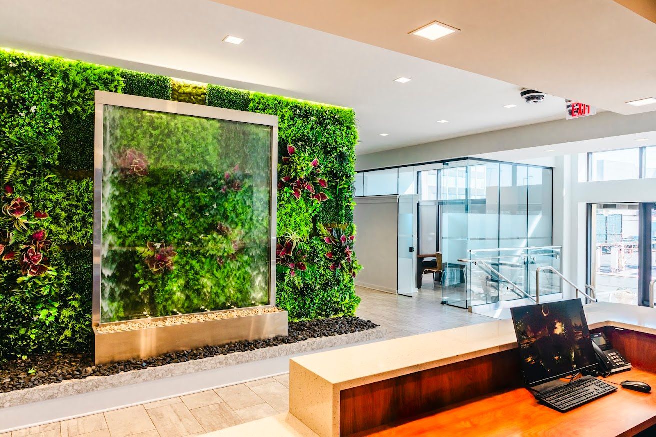 A reception area with a green wall and a waterfall.