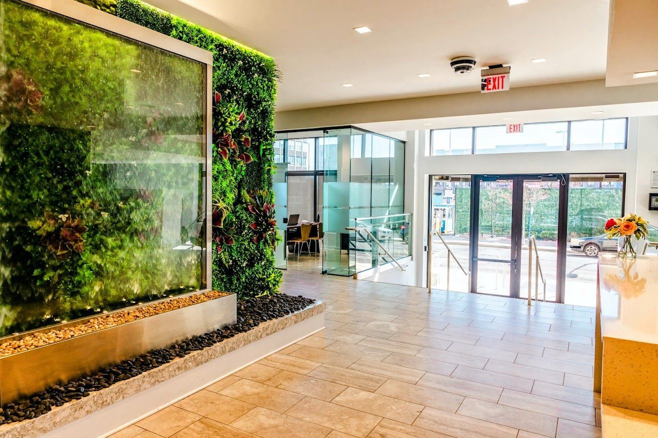 A lobby with a green wall and a water fountain.