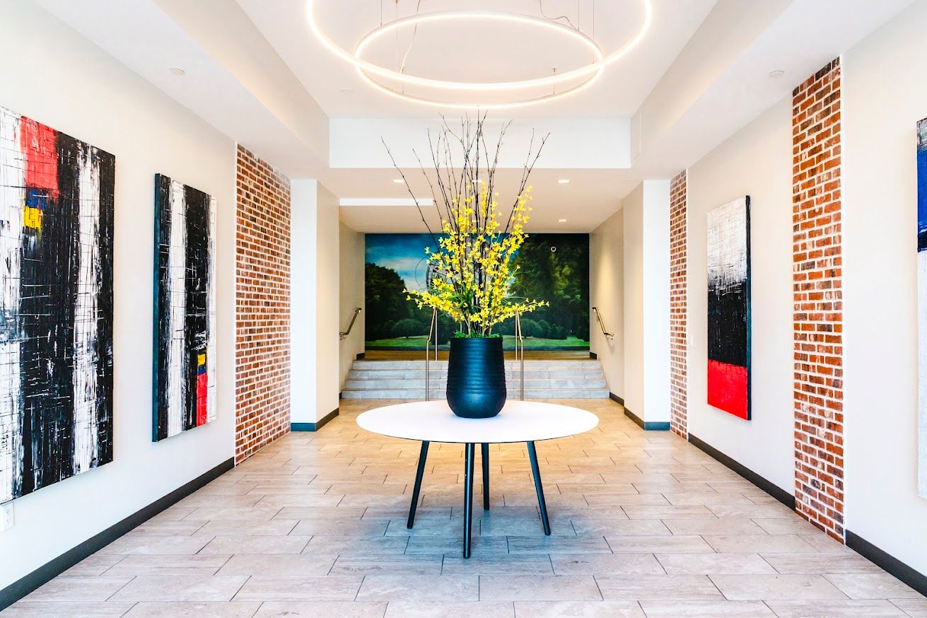 There is a vase of flowers on a table in the middle of a hallway.