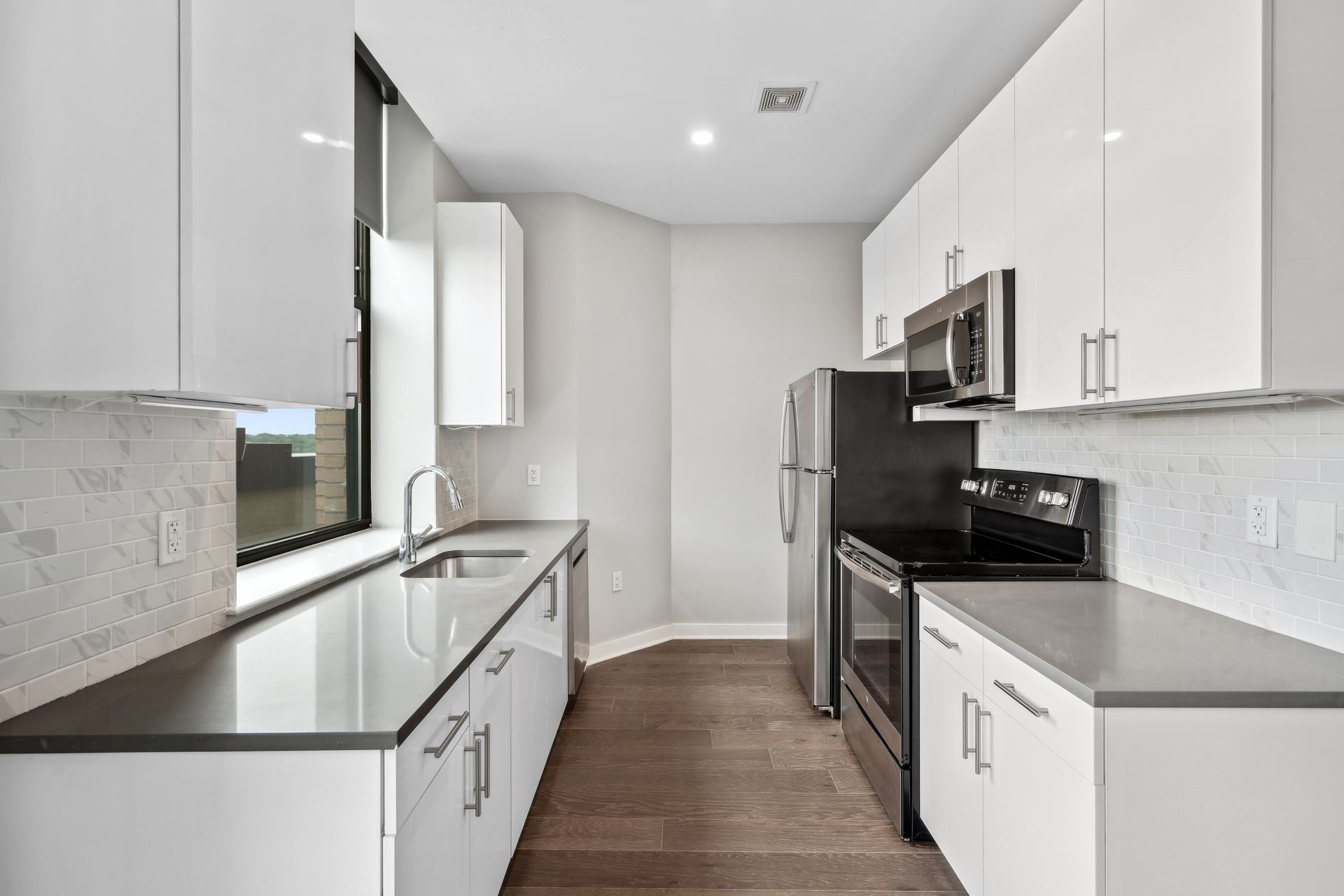 A kitchen with white cabinets and stainless steel appliances.