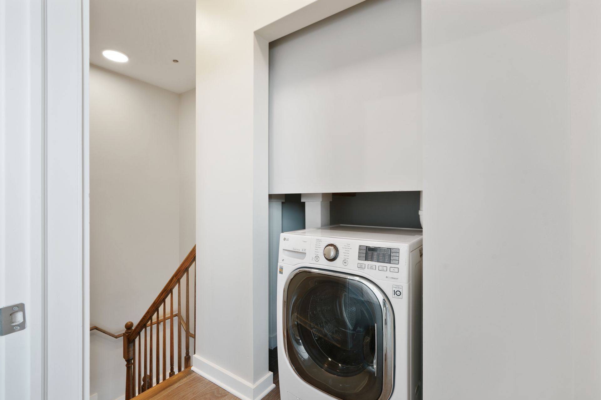 A washer and dryer are built into the wall in a laundry room.
