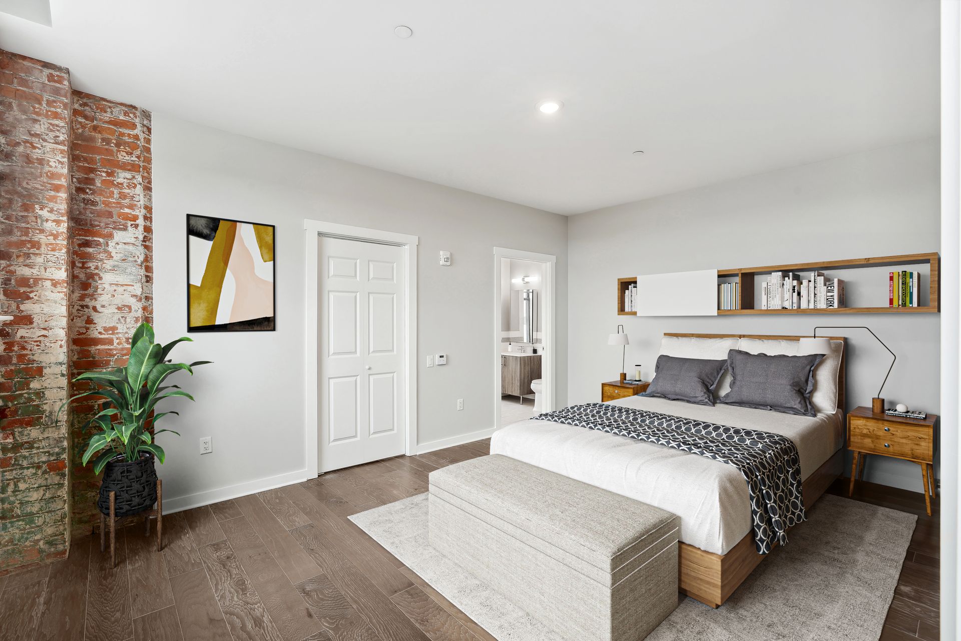 A bedroom with a large bed and a brick wall.